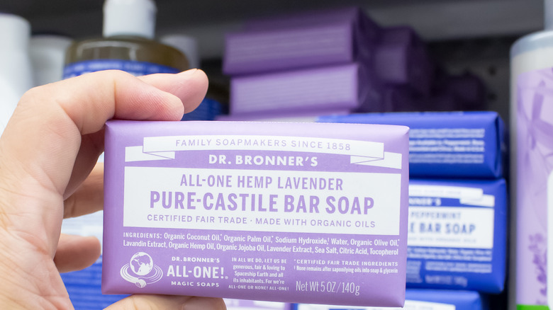 hand holding up a purple bar of Dr. Bronner's soap 
