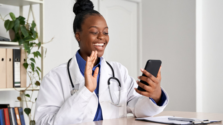 Doctor with iPhone conducting online appointment