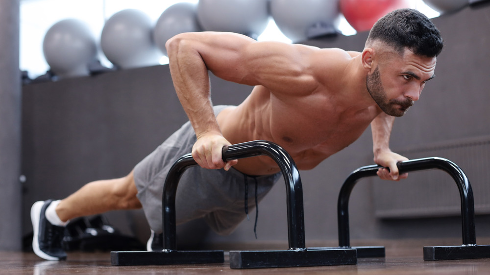 man using parallel bars for push-up