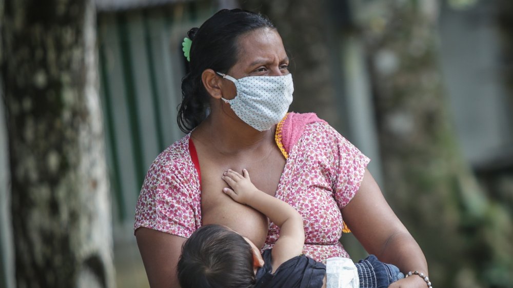 mother breastfeeding with face mask