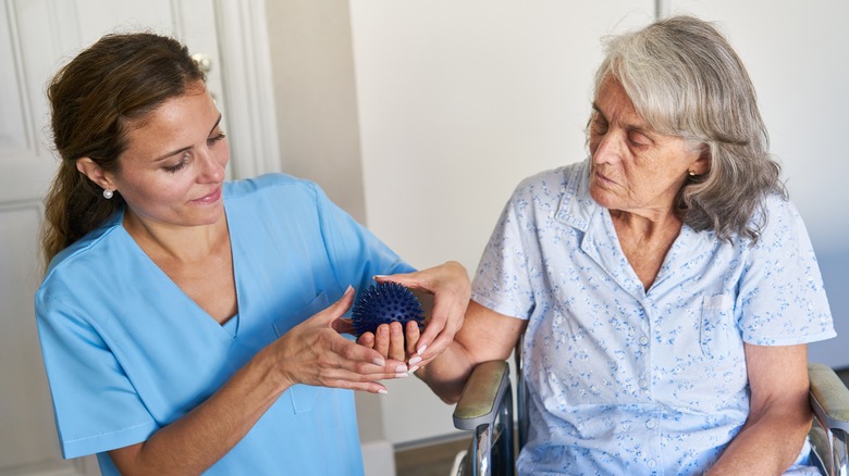 A nurse helps an elderly woman