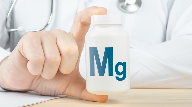 doctor holding magnesium tablet bottle
