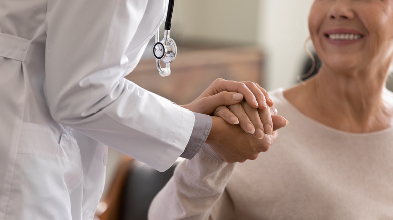 doctor holding a patient's hand 