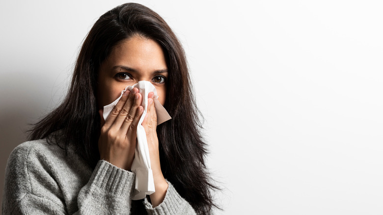 lady holding nose with handkerchief