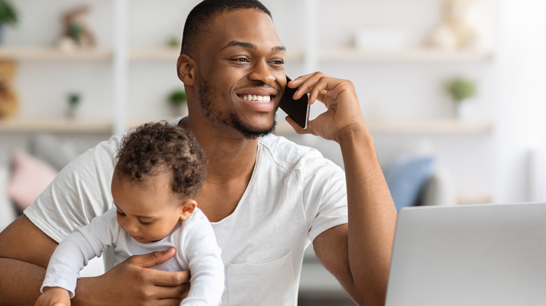 Man on phone holding child