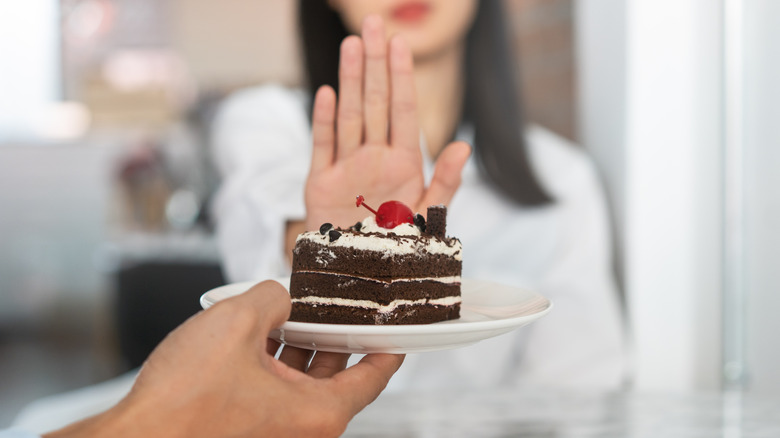 woman refusing slice of cake