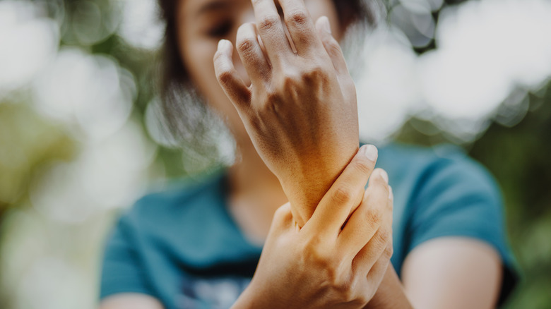 woman holding wrist in pain 