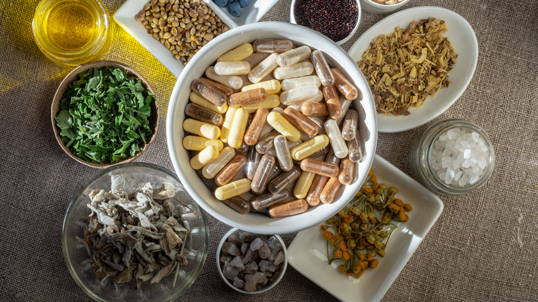 Assortment of supplements and herbs in bowls on a table