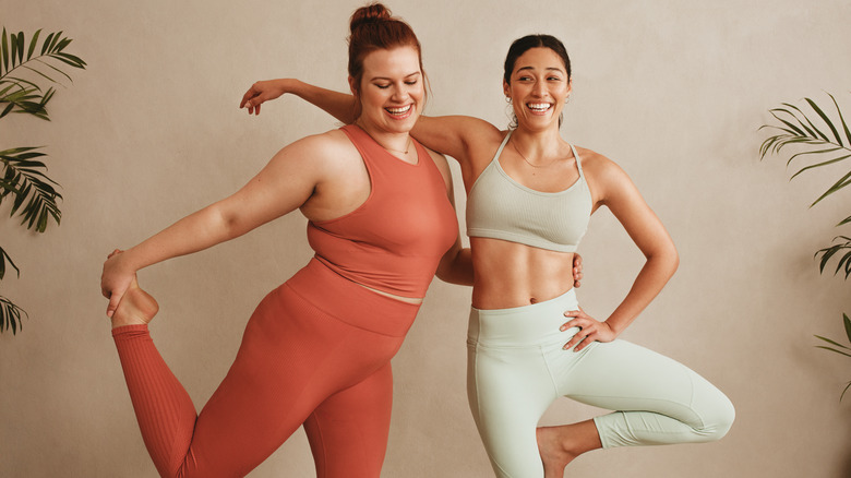 Two women standing together and smiling in exercise clothes