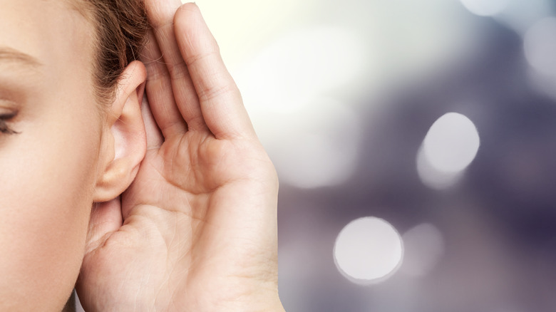 person cupping ear