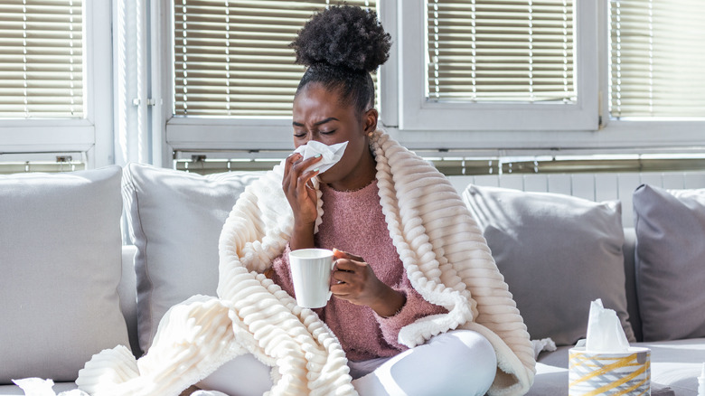 sick woman blowing her nose