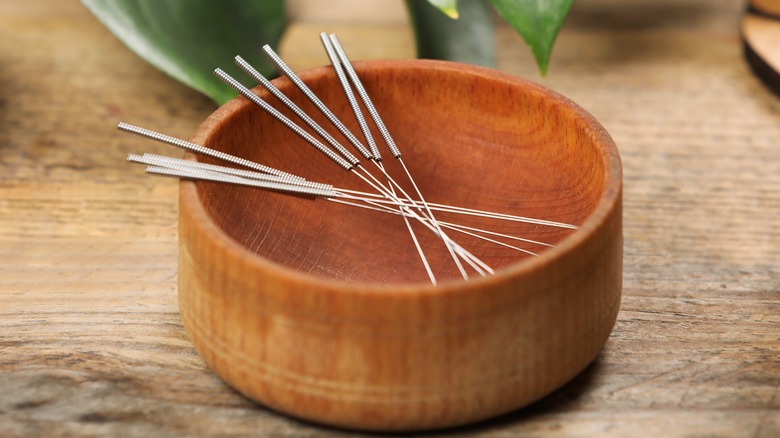 acupuncture needles in wooden bowl