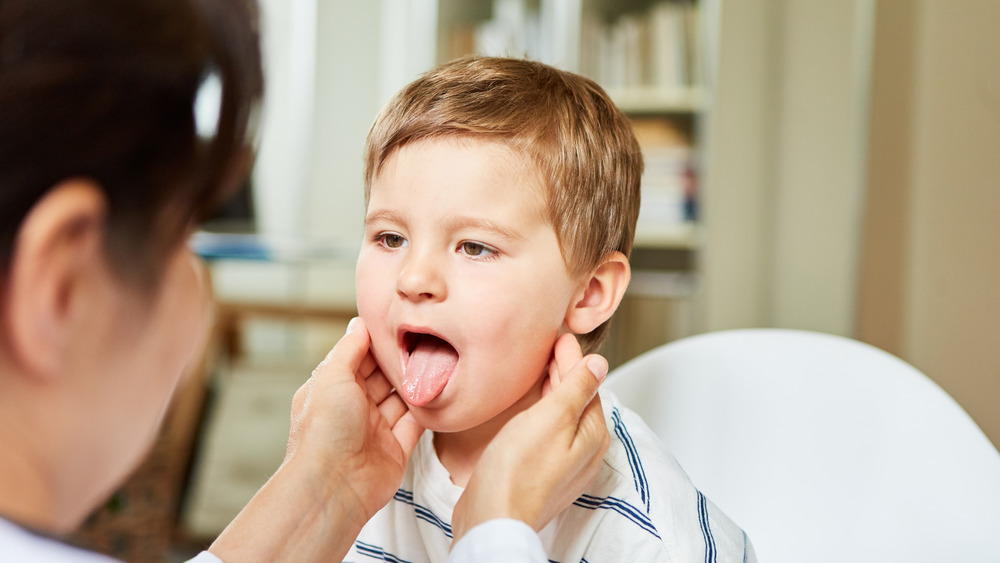 Doctor checking child's tongue