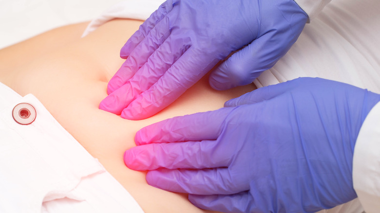 Doctor with gloves addressing uterine pain