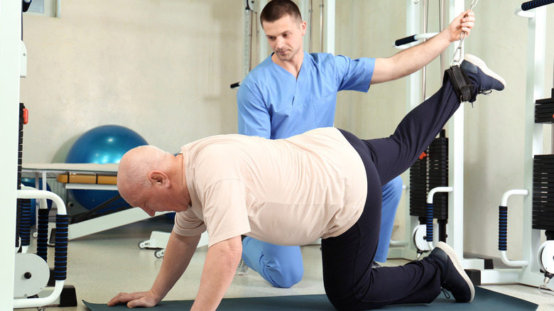 Older man working with physical therapist