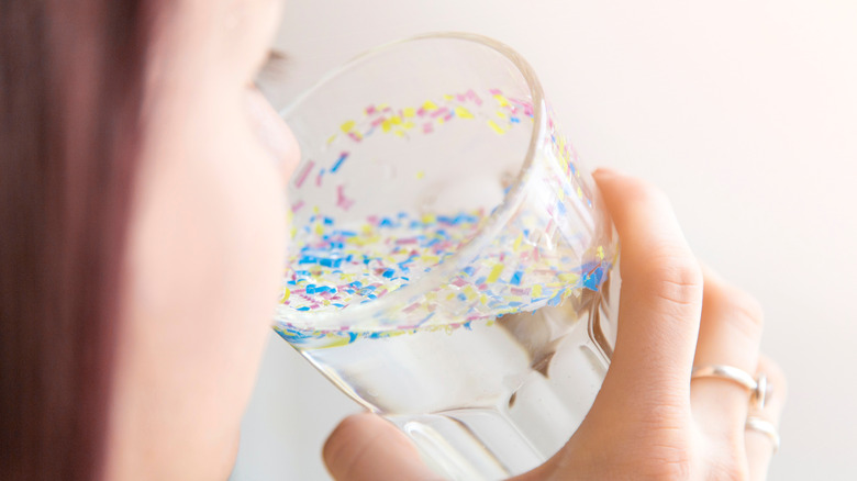 Woman drinking water with microplastics 