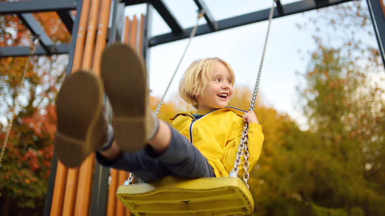 little boy having fun on a swing