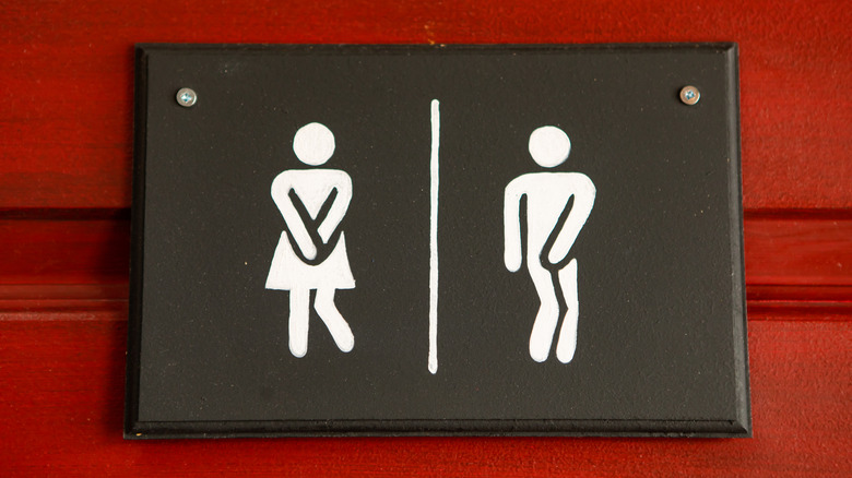 female-male restroom sign indicating urgent need to pee