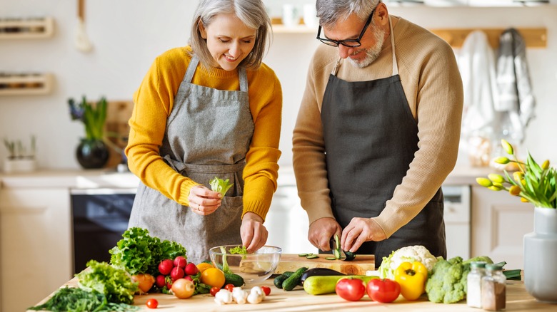 older man and woman preparing a fiber-rich meal in their kitchen