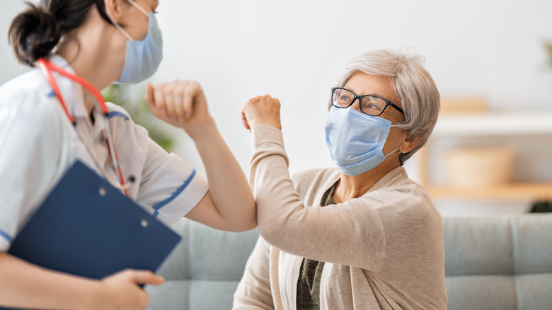 Doctor and woman wearing facemasks during coronavirus