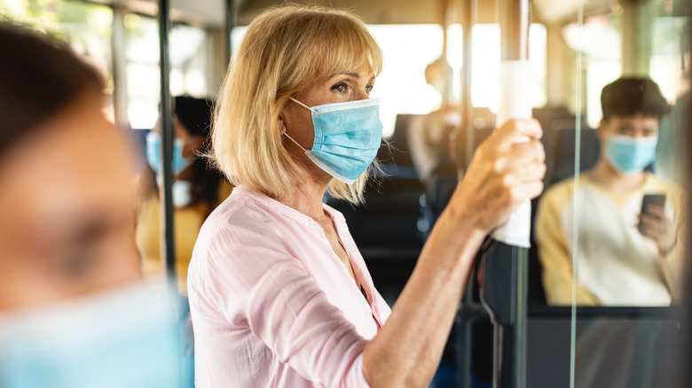 Senior woman wearing mask on bus