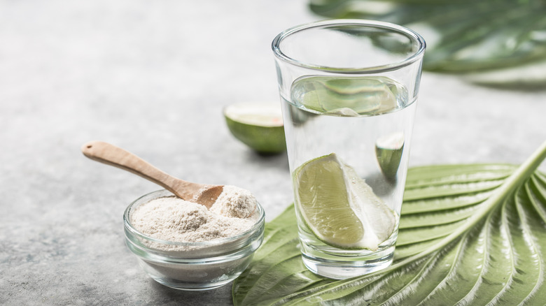 Powdered collagen next to a glass of water