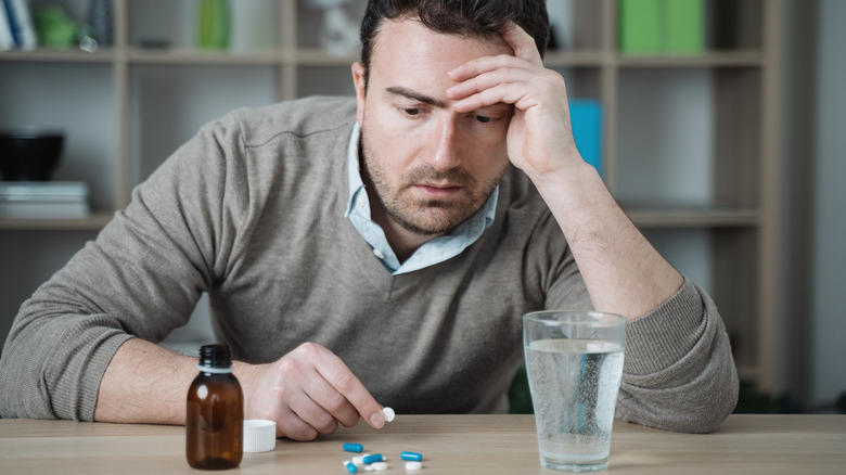 A man looking at his medication