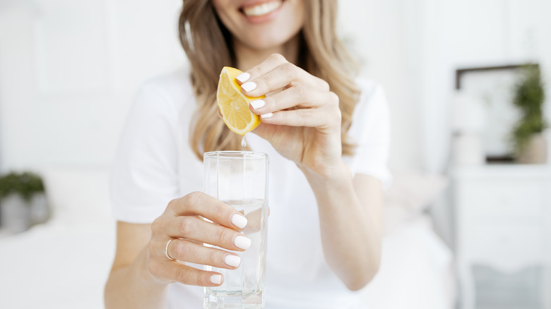 Woman squeezing lemon into water