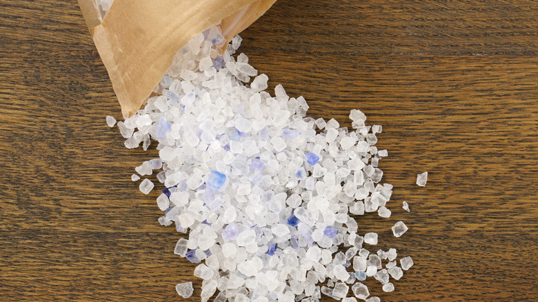 Persian blue salt pouring out of a bag onto a wood surface