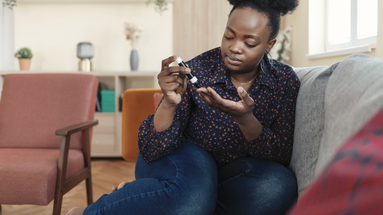 young woman checking blood sugar with glucometer