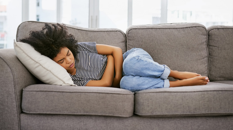 woman curled up on sofa