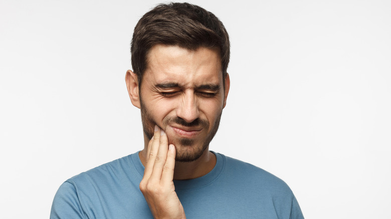 man holding jaw in pain