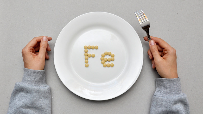 an empty plate with the letters fe on it signaling iron deficiency