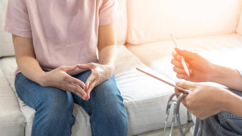 a nervous woman sitting at the doctor