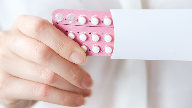 woman holding a birth control pack