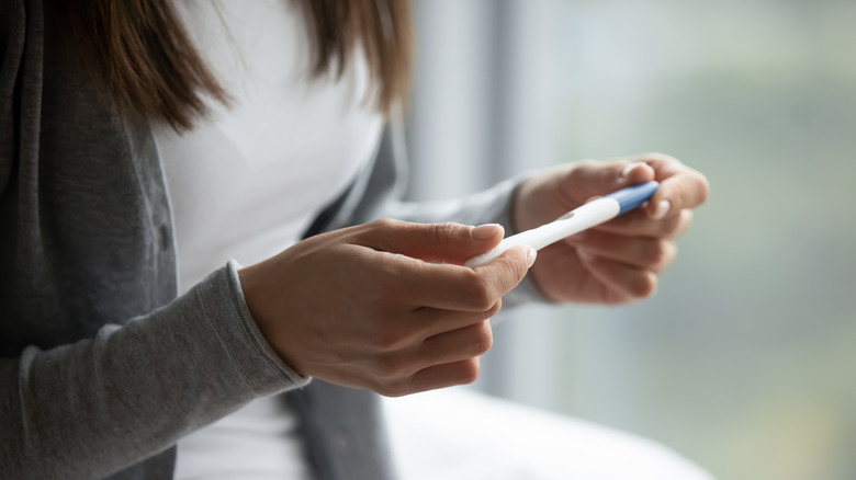 a woman holding a pregnancy test