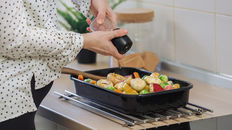 pregnant woman putting spices on food