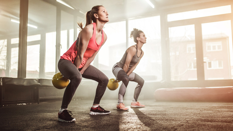 Two women performing kettlebell swings