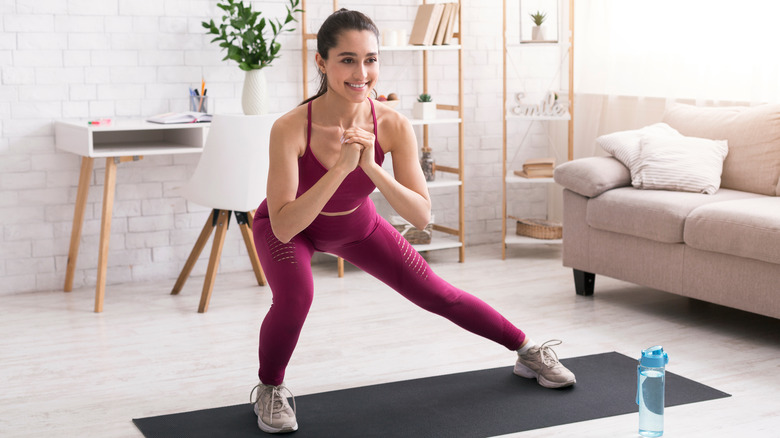 A woman does side lunges at home