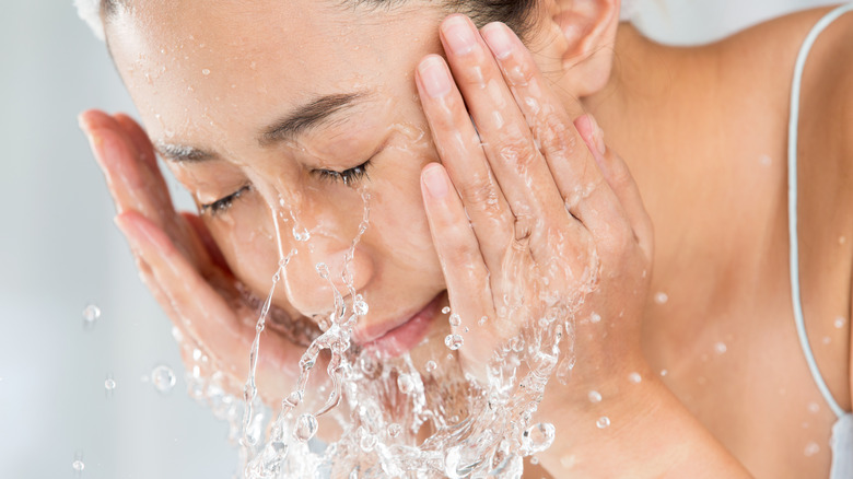 woman putting water on skin