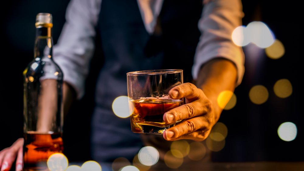 Man passing glass of whiskey