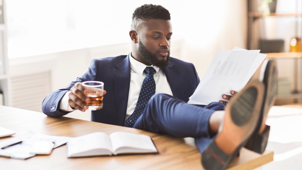 Mn drinking whiskey at his desk