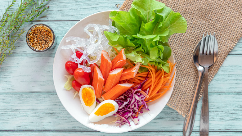 imitation crab meat on plat with egg, butter lettuce, and carrots