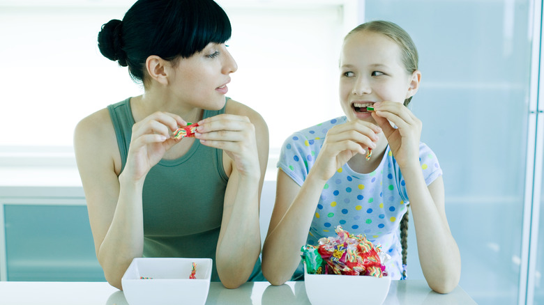 woman and daughter eating hard candy