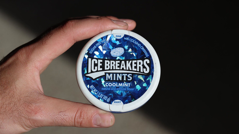 man's hand holding Ice Breakers mint package