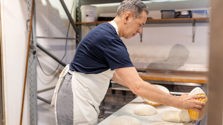 man working with rising bread dough