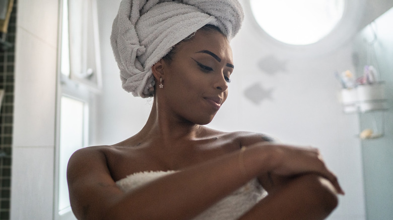 Woman applying moisturizer