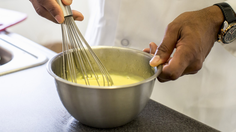 man mixing together egg product