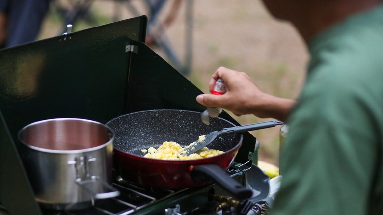 person cooking scrambled eggs