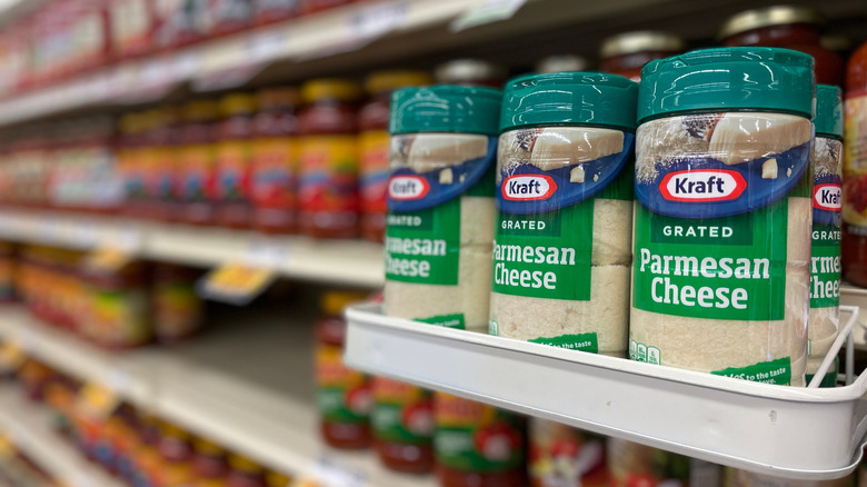 A few shakers of Kraft Parmesan cheese on a grocery store shelf